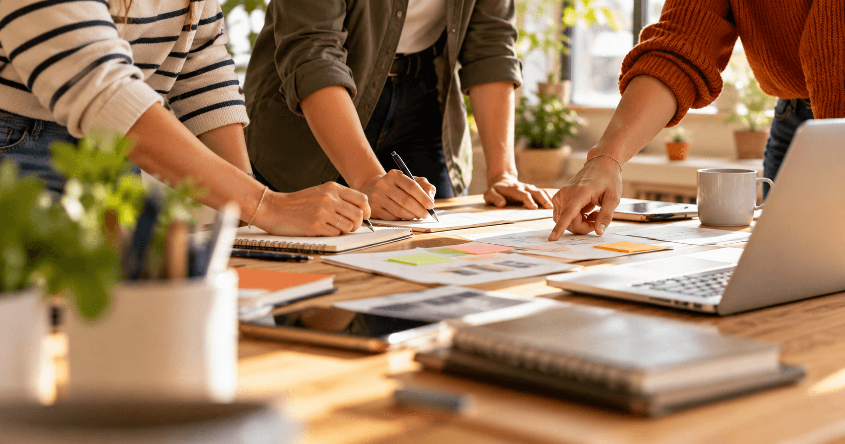 3 personnes travaillent ensemble sur un bureau